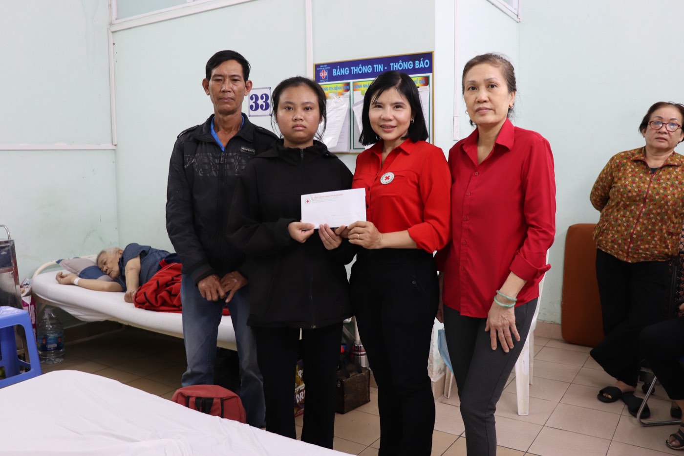 Cán bộ Chữ thập đỏ trao quà hỗ trợ cho gia đình người bệnh